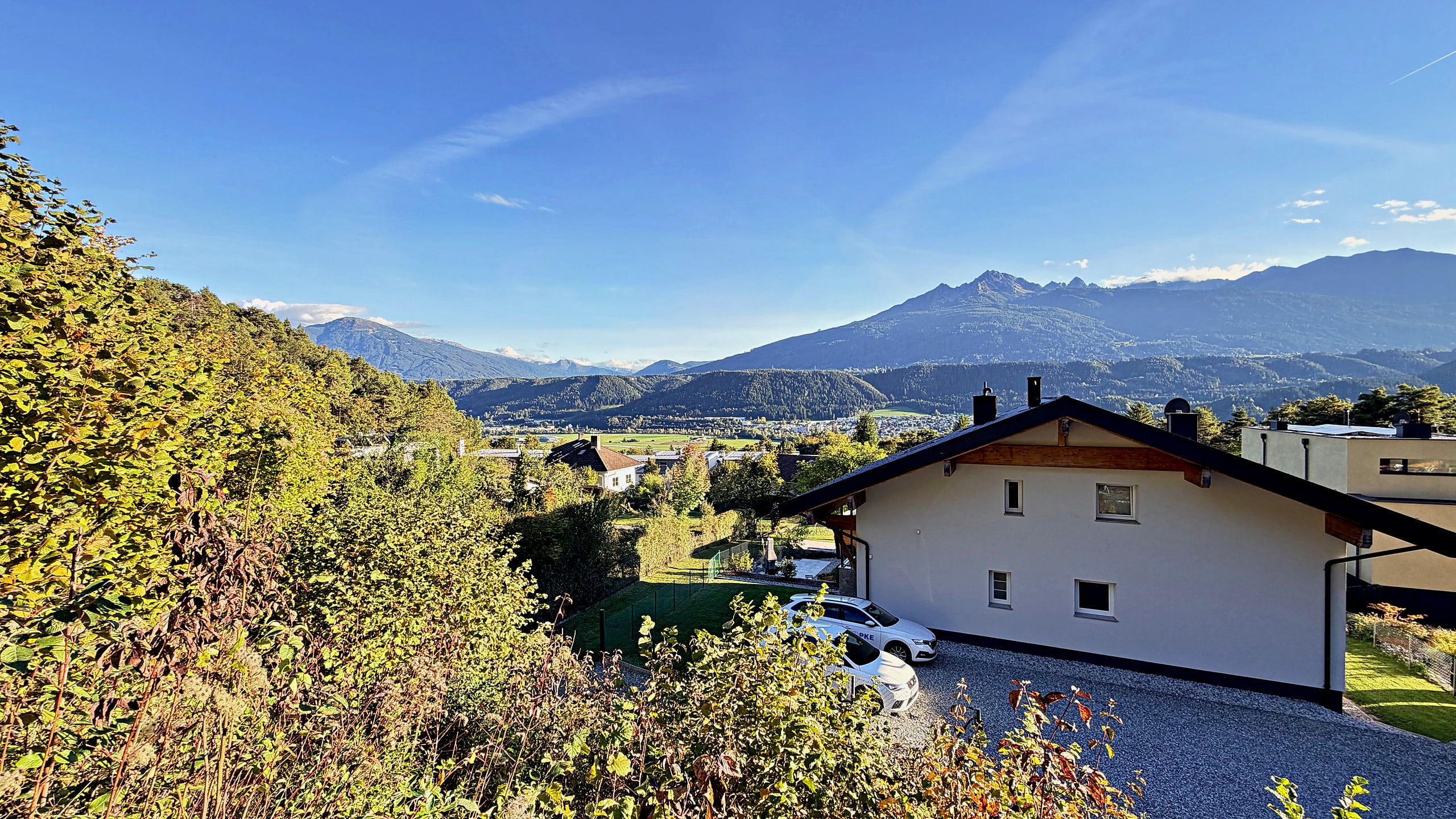 Blick vom Hang über das Haus und das Inntal auf die Bergkette